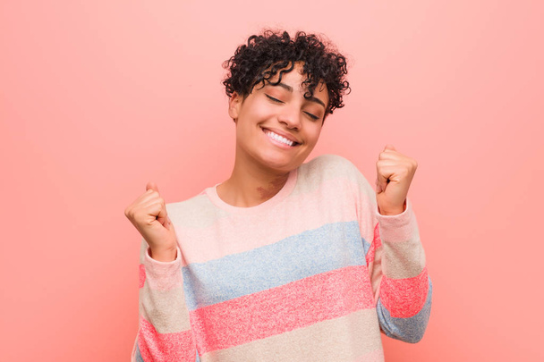 Jeune femme adolescente afro-américaine mixte élevant le poing, se sentant heureuse et réussie. Concept de victoire
. - Photo, image