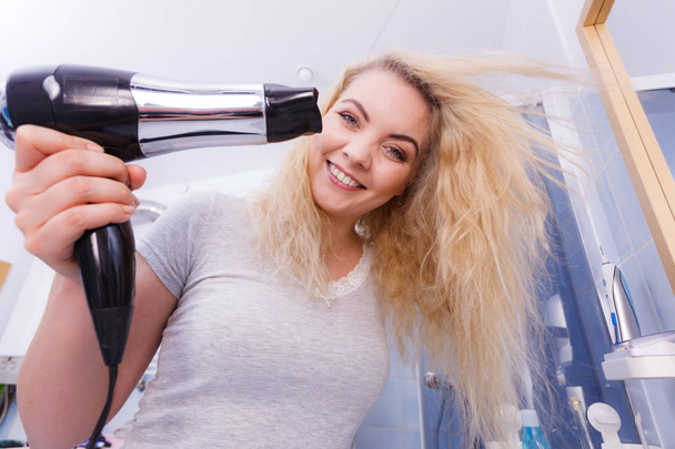 Woman drying hair in bathroom - Foto, afbeelding