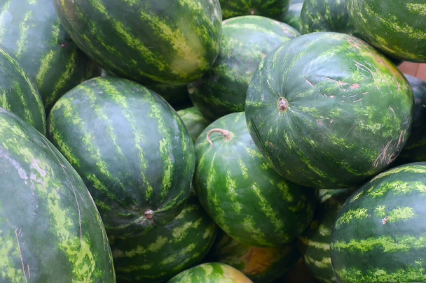 egy rakás nagy érett lédús görögdinnye a piacon - Fotó, kép