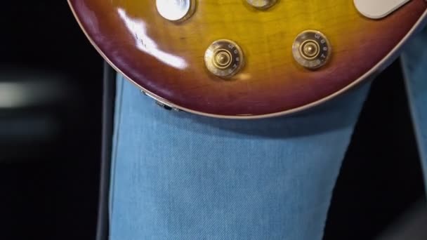 männlicher Gitarrist steckt Kabel in Buchse seiner E-Gitarre. - Filmmaterial, Video