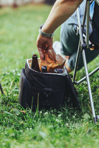 hombre mano tomando chips de bolsa de enfriamiento con cerveza
 - Foto, imagen