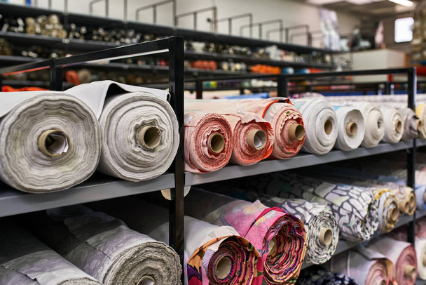Fabric warehouse with many multicolored textile rolls - Fotografie, Obrázek