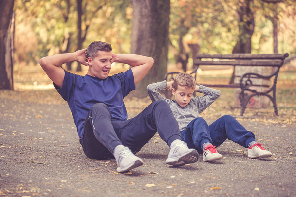 Little boy and his father doing stretching exercise together  - Φωτογραφία, εικόνα