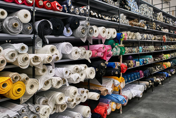 Fabric warehouse with many multicolored textile rolls - Фото, изображение