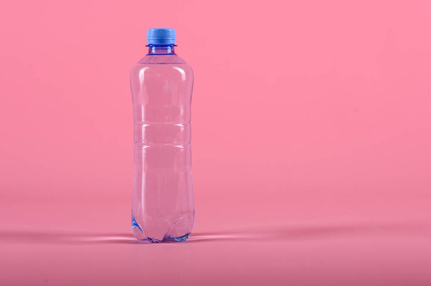 Plastic bottle of still healthy water isolated on pink background - Foto, Bild