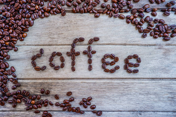 la palabra café hecho de granos de café sobre fondo de madera
 - Foto, Imagen