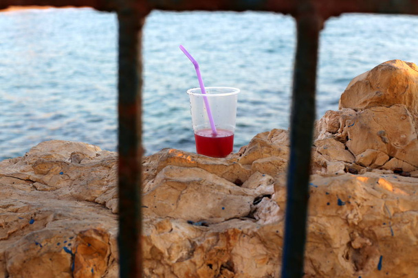 холодна питна вода наливається в пластикову чашку і пляшку
  - Фото, зображення