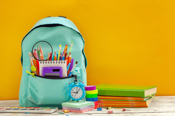 Full School Backpack with different supplies on orange background. Concept back to school. - Foto, Bild
