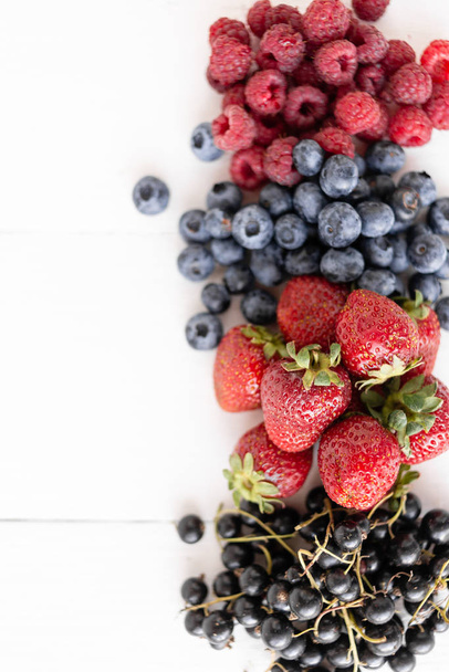 Berries, on a white background. Ripe blueberries, blackberries, black currants, raspberries, - Foto, Bild