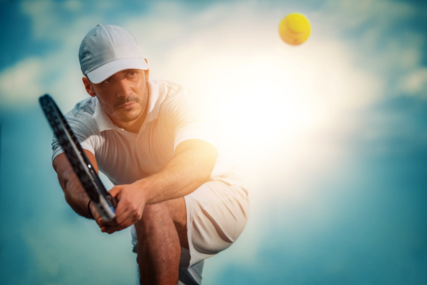 Теннисист сосредоточен в готовой позиции.Он на теннисном корте. - Фото, изображение