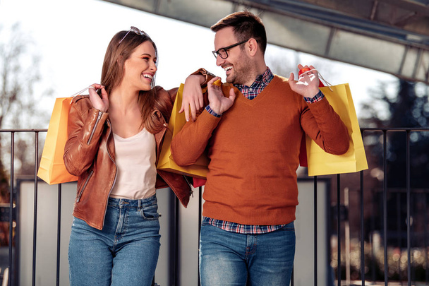 Όμορφο νεαρό ζευγάρι απολαμβάνει στα ψώνια, έχοντας τη διασκέδαση στην πόλη. - Φωτογραφία, εικόνα
