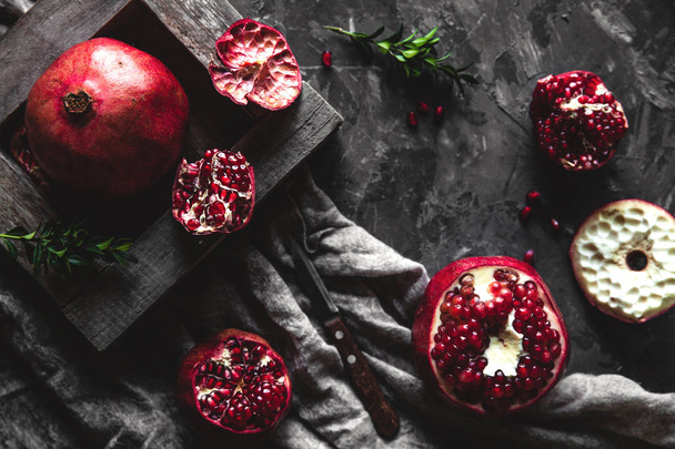 Fresh pomegranate in a wooden box. On a gray background. Top view. Copy space. - Foto, Bild