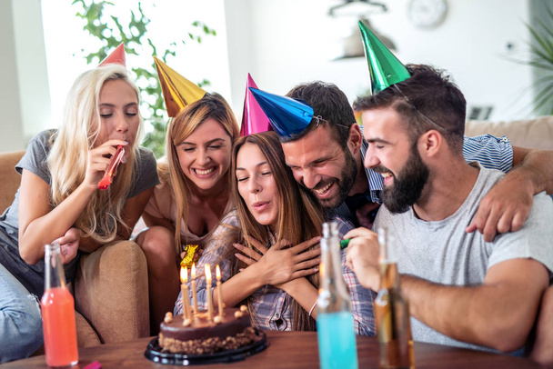 Святкування, їжа, друзі, вечірка і день народження концепція-жінки дме свічки на її день народження торт
. - Фото, зображення