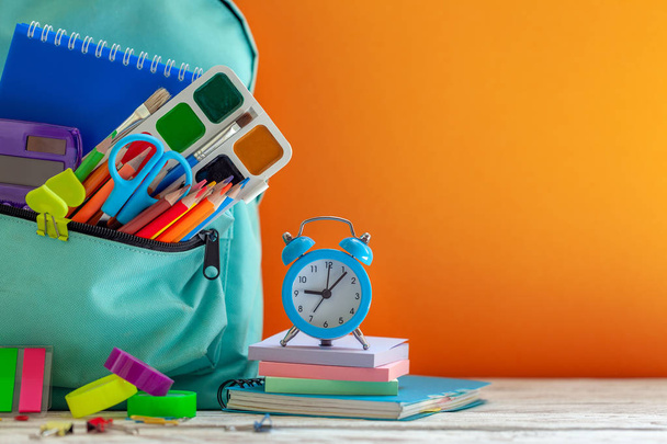 Full School Backpack with different supplies on orange background. Concept back to school. - Valokuva, kuva