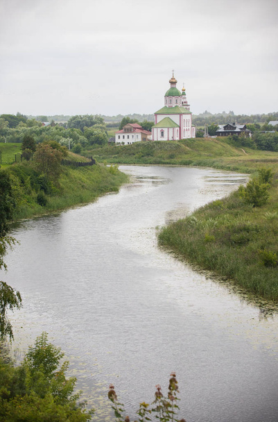 die Landschaft des kleinen Dorfes - der Fluss - die große Kirche auf dem Hintergrund - suzdal, russland - Foto, Bild