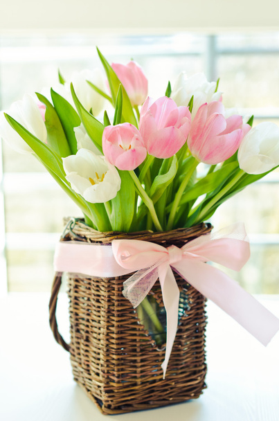 Rózsaszín és fehér tulipán egy fonott kosárban - Fotó, kép