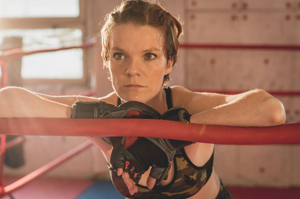 Fiatal nő készül mérkőzések MMA a ketrecben. Tréning egy sportcsarnokban - Fotó, kép