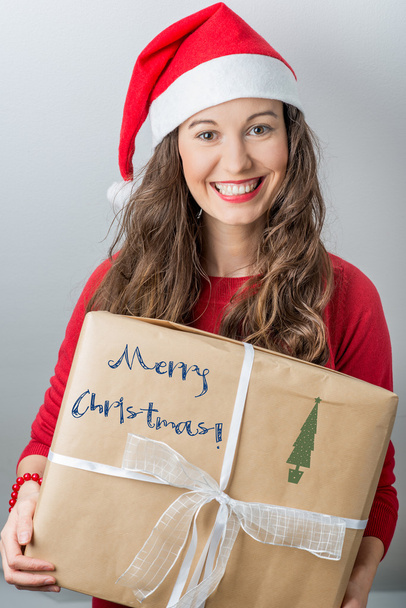Christmas woman holding gifts wearing Santa hat - Foto, Imagem