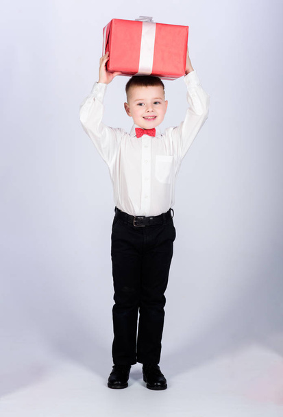 tuxedo style. Happy childhood. Birthday party. Shopping. Boxing day. New year. little boy with valentines day gift. happy child with present box. Christmas. shop assistant giving package. package. - Фото, изображение