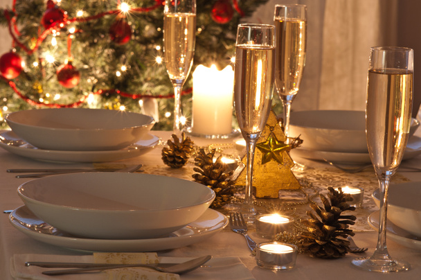 Şampanya kadehli süslü bir Noel yemeği masası. - Fotoğraf, Görsel