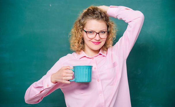 Energy charge for whole day. Teacher eyeglasses drink coffee chalkboard background. Woman enjoy coffee before classes. Sip recharging body and mind. Dose of caffeine. Back to school. Coffee addicted - Φωτογραφία, εικόνα