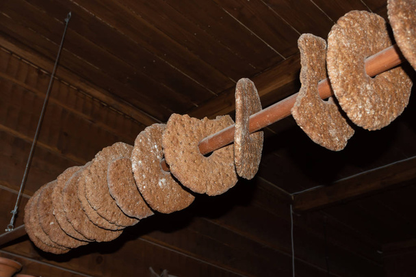 Roggebrood drogen op een paal. Traditionele manier om brood op te slaan in een boerderij, hangend aan een paal in het plafond - Foto, afbeelding