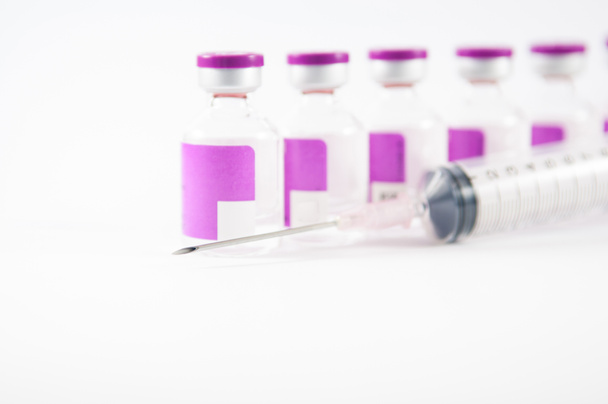 Arrange purple vial and disposable syringe on white background - Photo, Image