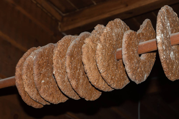 Roggebrood drogen op een paal. Traditionele manier om brood op te slaan in een boerderij, hangend aan een paal in het plafond - Foto, afbeelding