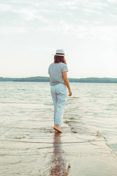 woman in white clothes walking by sea beach - Foto, imagen