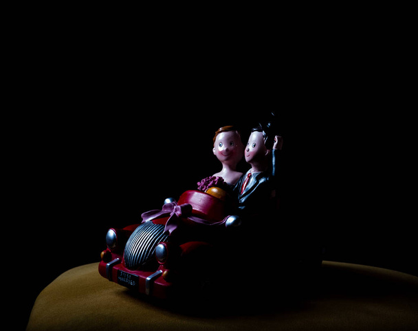 Coche de juguete de cerámica con pareja casada tiro bajo llave
 - Foto, Imagen