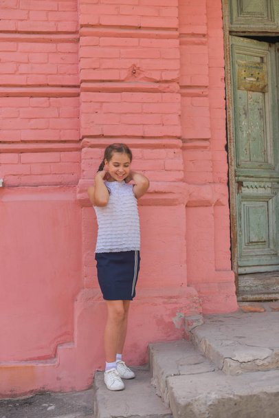 крупным планом портрет маленькой красивой стильной девочки возле стены из красного кирпича в качестве фона
 - Фото, изображение