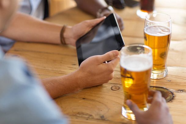 men with tablet computer drinking beer at bar - Foto, afbeelding