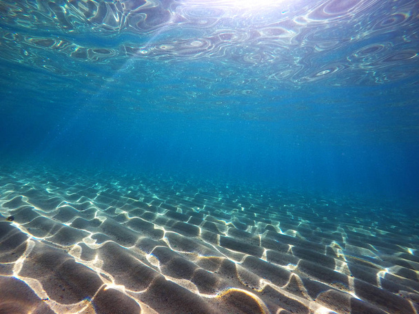 Bajo el agua disparado con rayos de sol en la arena
 - Foto, imagen