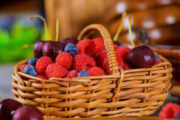 Ассортимент свежих ягод, черники, вишни, малины летом свежие ягоды в корзине
 - Фото, изображение