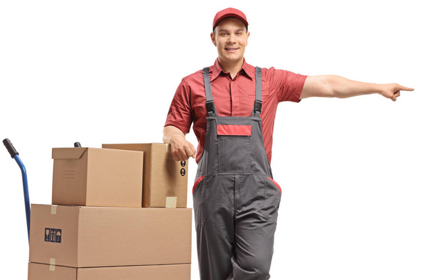 Чоловік працівник спирається на ручну вантажівку зі стопкою коробок і po
 - Фото, зображення