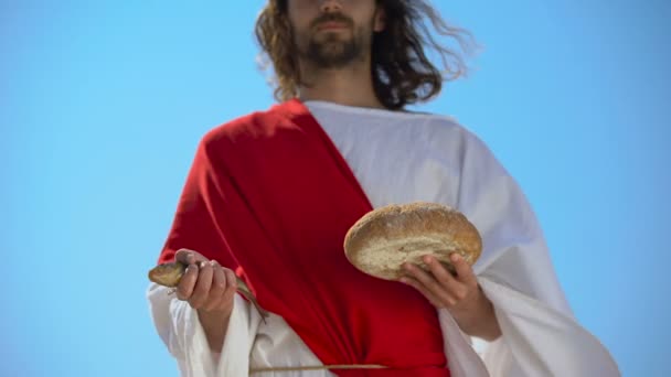 El hombre con la túnica sosteniendo el pescado y el pan, concepto de caridad para alimentar hambriento, generosidad
 - Metraje, vídeo