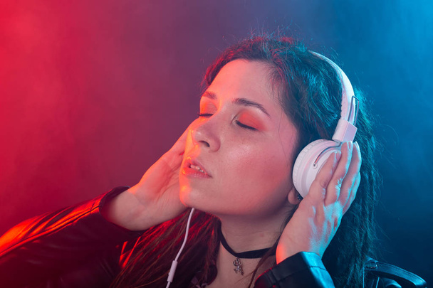 Νεαρή γυναίκα με ράμες απολαμβάνει τη μουσική στα ακουστικά της - Φωτογραφία, εικόνα