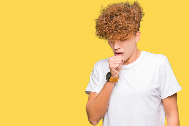 Mladý pohledný muž s afro vlasy nosí ležérní bílé tričko pocit nepohody a kašle jako příznak nachlazení či zánět průdušek. Zdravotnické koncepce. - Fotografie, Obrázek