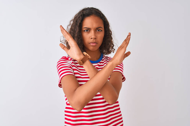 Jeune femme brésilienne portant t-shirt à rayures rouges debout sur fond blanc isolé Expression de rejet croisant les bras faisant signe négatif, visage en colère
 - Photo, image