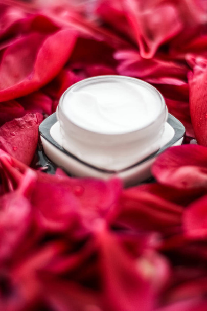 Чувствительный крем для увлажнения кожи на лепестках красных цветов и ва
 - Фото, изображение