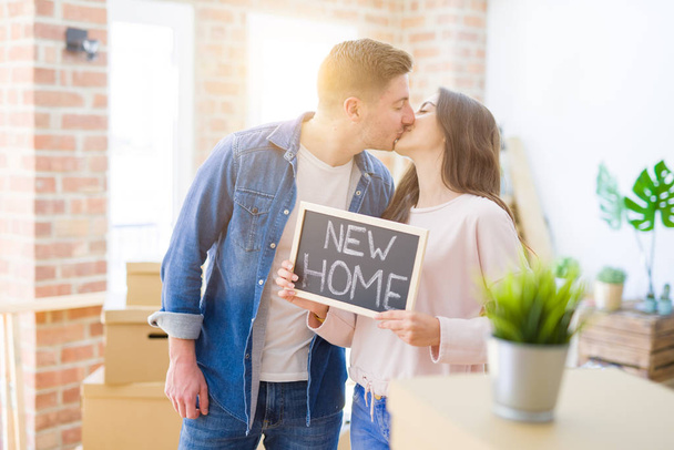 Kaunis nuori pari halaus rakastunut ja tilalla liitutaulu siirtymässä uuteen kotiin, hymyillen onnellinen uusi asunto
 - Valokuva, kuva