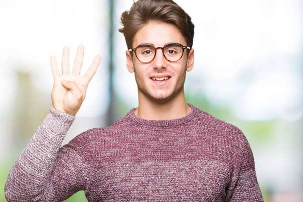 Молодой красивый мужчина в очках на изолированном фоне показывает и указывает пальцами номер четыре, улыбаясь уверенно и счастливо
. - Фото, изображение