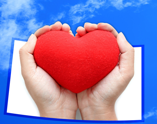Simbolo del cuore rosso su sfondo cielo blu mani
 - Foto, immagini