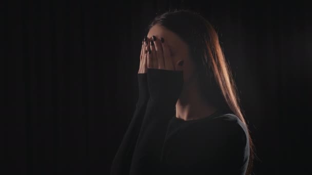 Chica en una habitación oscura asustada y cubriendo sus ojos
 - Imágenes, Vídeo