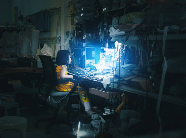 Маленькая девочка сидит перед синим экраном монитора, как техническая рутина в службе ремонта компьютеров и телефонов с грязным офисным столом. Концепции научной фантастики
 - Фото, изображение