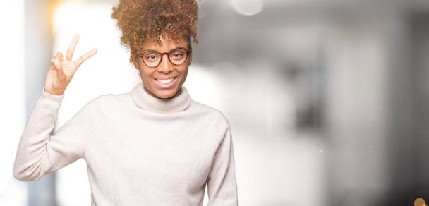 孤立した背景表示と指で上向きに眼鏡をかけて美しい若いアフリカ系アメリカ人女性数は自信を持って、幸せな笑みを浮かべている間 2. - 写真・画像