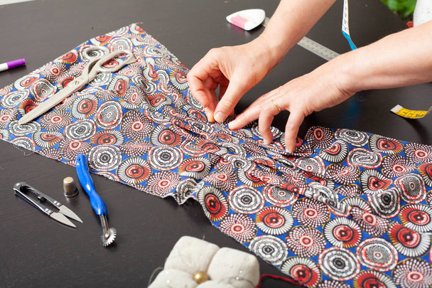 Dressmaker op het werk, bouw patronen, handen, modellering, meten, naaimachine - Foto, afbeelding
