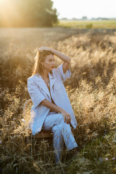 Fashion photo of attractive blonde woman in blue suit in wheat field. - Φωτογραφία, εικόνα