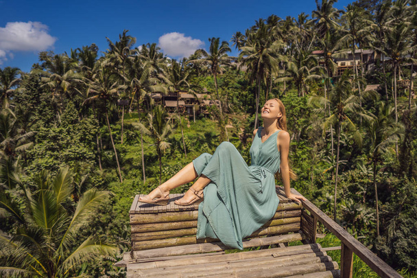 Beautiful young woman walk at typical Asian hillside with rice farming, mountain shape green cascade rice field terraces paddies. Ubud, Bali, Indonesia. Bali travel concept - 写真・画像