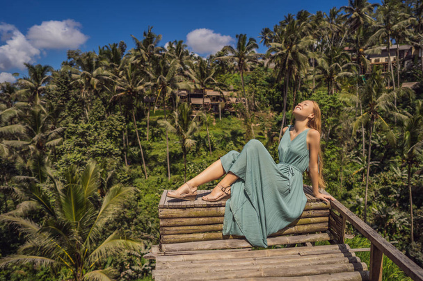 Beautiful young woman walk at typical Asian hillside with rice farming, mountain shape green cascade rice field terraces paddies. Ubud, Bali, Indonesia. Bali travel concept - Фото, изображение